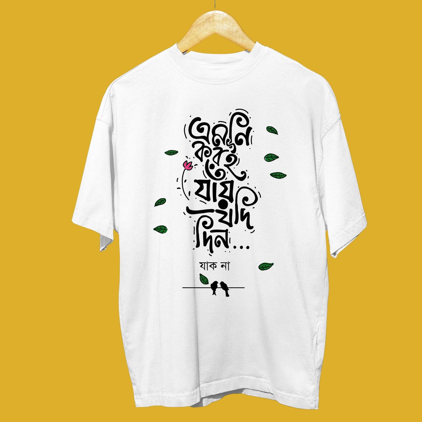 White oversized unisex T-shirt with Bengali typography 'Emni Korei Jaye Jodi Din' and decorative floral and leaf elements.