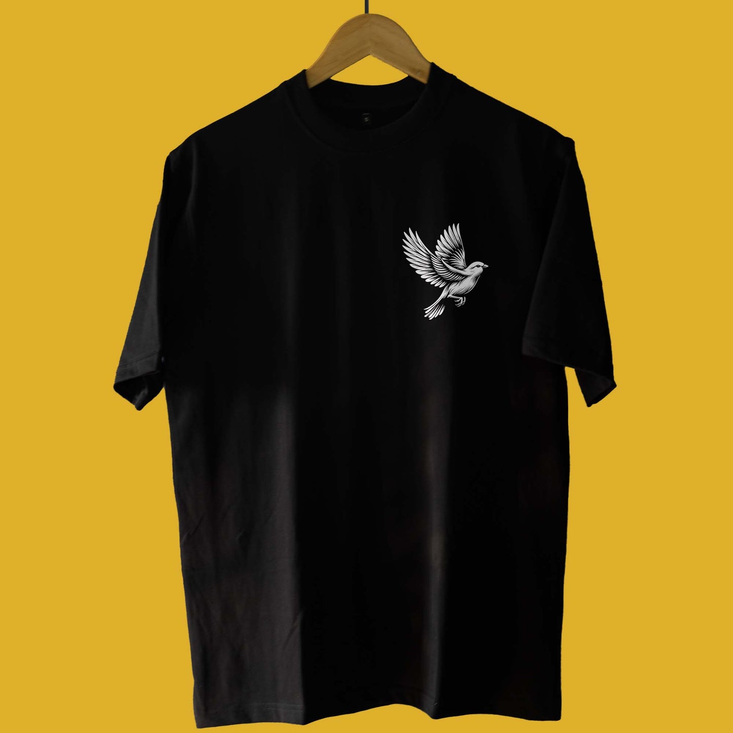 Front view of Harai Harai oversized unisex Bengali T-shirt in black, featuring a minimalist bird design on the chest.