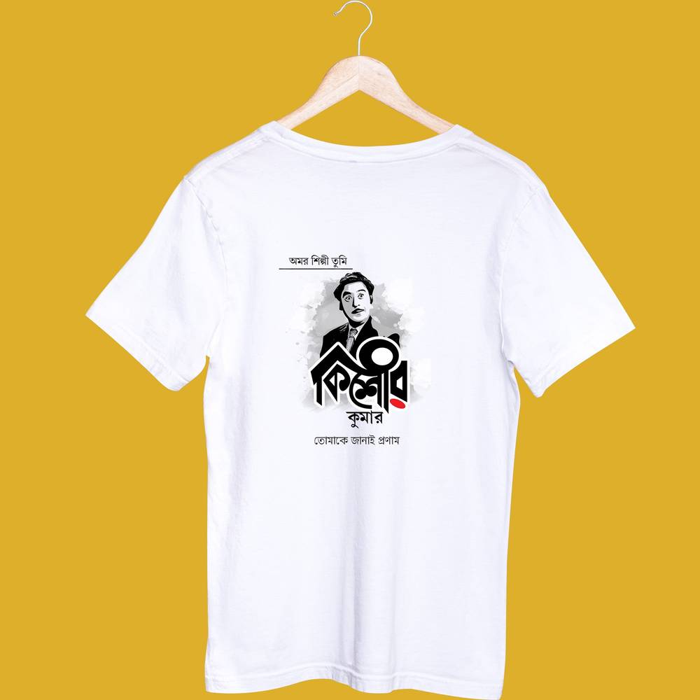 White unisex T-shirt featuring a Kishore Kumar graphic design in Bengali script, displayed on a hanger against a yellow background.