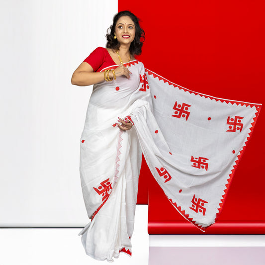 Swastik Shubha cotton saree in white with red appliqué Swastika motifs and zigzag border, ideal for festivals and weddings.