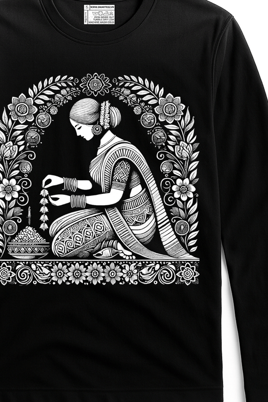 Malini Alpona Art T-shirt features intricate Bengali folk art of a woman creating Alpona, printed in white on a black full sleeves cotton tee. Unisex fit ideal for cultural fashion lovers.