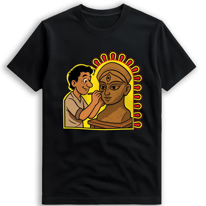 Idol Maker T-shirt close-up — Kumartuli artisan painting the eyes onto a Durga idol, illustrated tribute on black cotton