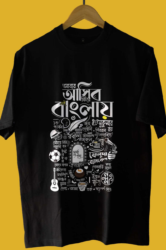Black oversized unisex T-shirt 'Abar Asibo Firey' featuring Bengali cultural elements and Jibanananda Das-inspired design on a yellow background.