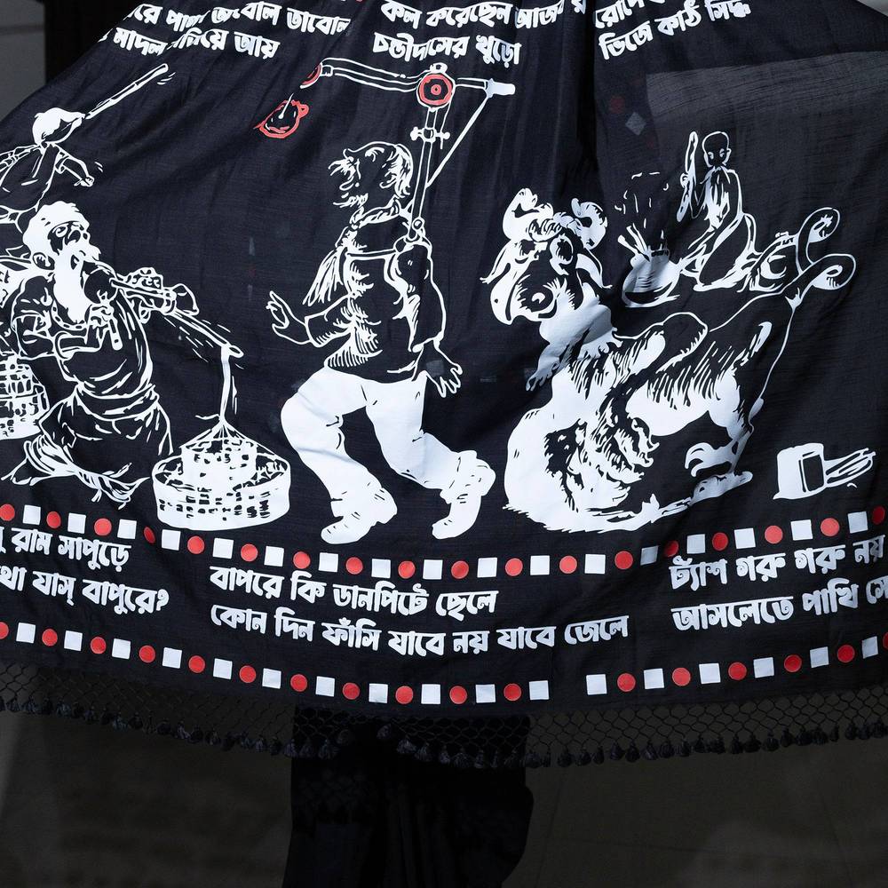 Close-up of Sukumar Ray illustrations and Bengali script on black saree