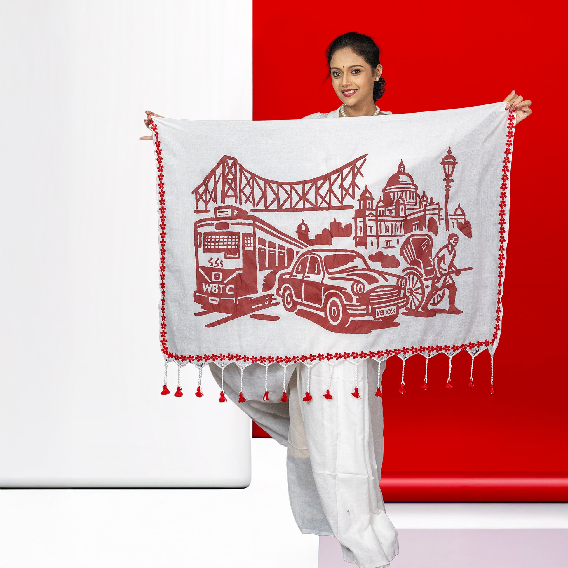White cotton Kolkata Heritage Saree with bold red graphic of tram, taxi, and Howrah Bridge, celebrating the city's cultural icons.