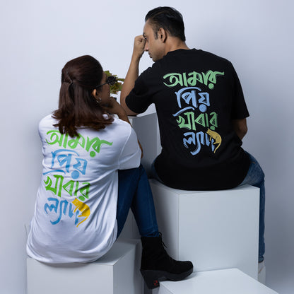 Couple wearing black and white 'Amar Priyo Khabar Lyadh' oversized Bengali T-shirts, perfect for Gen Z casual streetwear style.