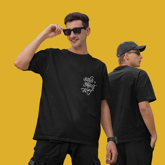 Two models wearing black oversized unisex T-shirts with 'Ami Amar Moto' Bengali typography; one facing forward and the other showing the back design.