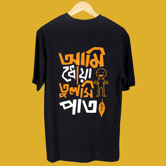 'Ami Dhowa Tulsi Pata' oversized Bengali graphic T-shirt in black with bold orange and white typography. Perfect for Gen Z streetwear fashion.