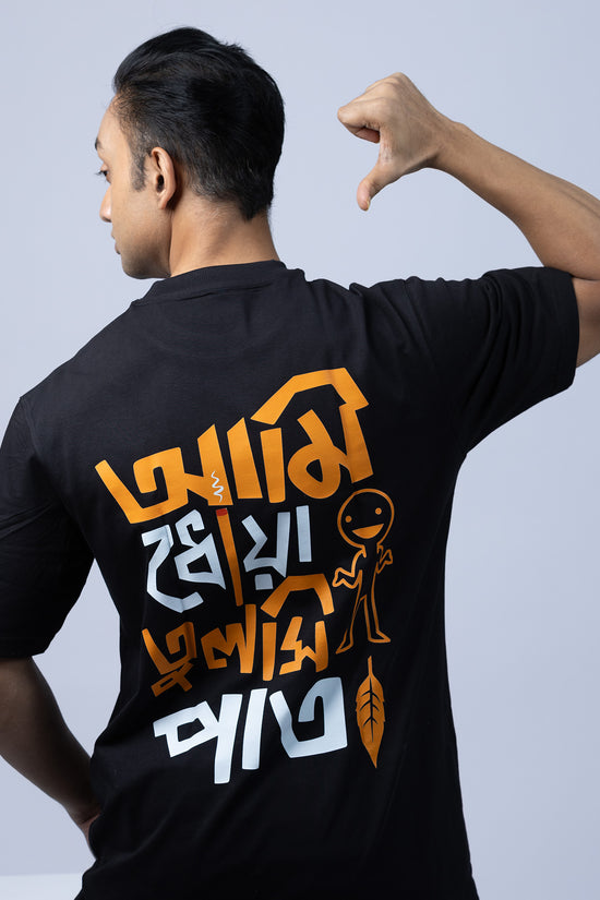 Model wearing 'Ami Dhowa Tulsi Pata' oversized Bengali graphic T-shirt, showcasing its trendy back print. A stylish unisex tee for Gen Z.