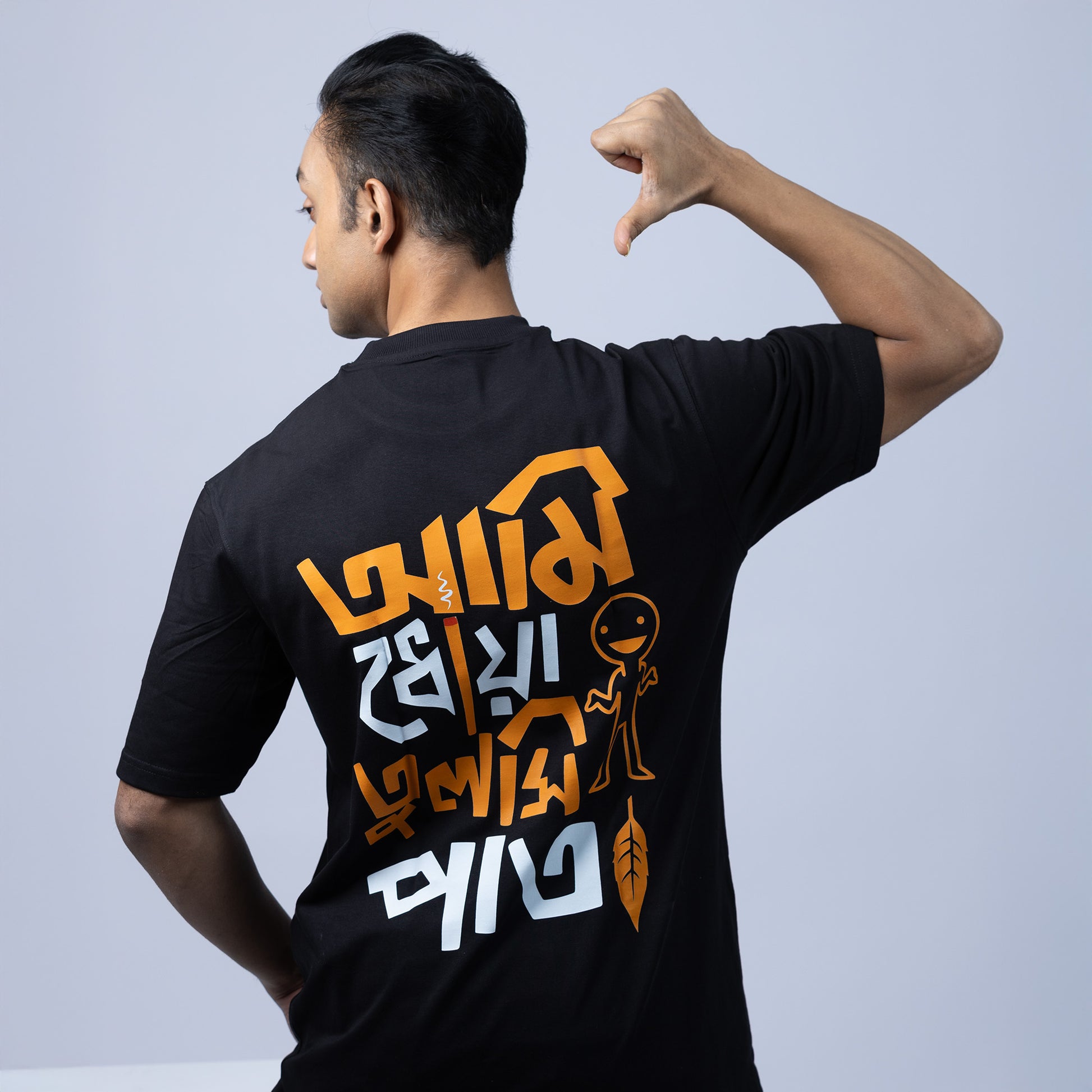 Model wearing 'Ami Dhowa Tulsi Pata' oversized Bengali graphic T-shirt, showcasing its trendy back print. A stylish unisex tee for Gen Z.
