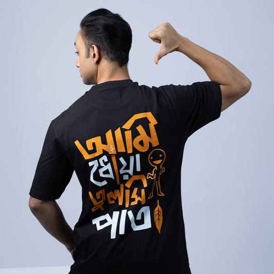 Model wearing 'Ami Dhowa Tulsi Pata' oversized Bengali graphic T-shirt, showcasing its trendy back print. A stylish unisex tee for Gen Z.
