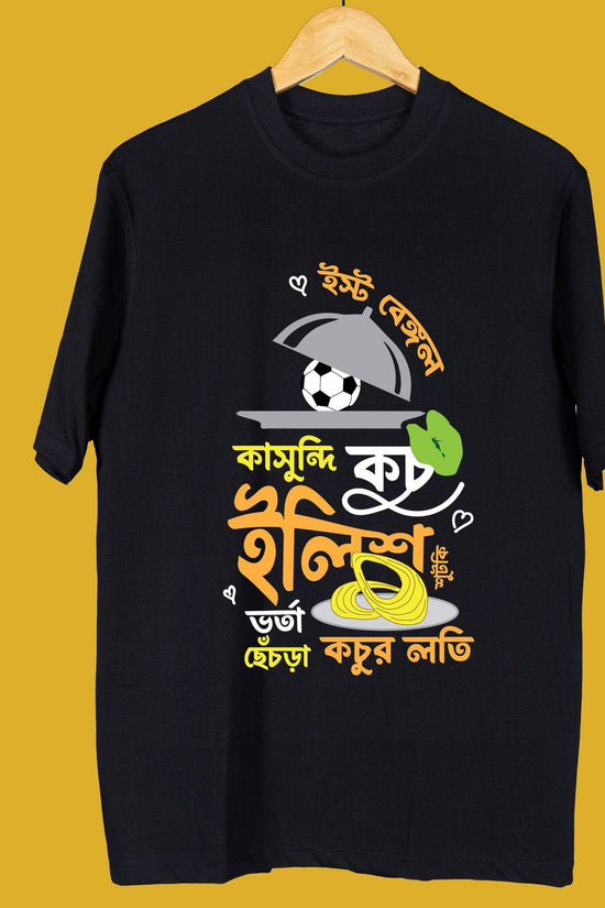 Black Bangal-kahini oversized unisex T-shirt displayed on a hanger, featuring vibrant Bengali typography and playful graphic design.