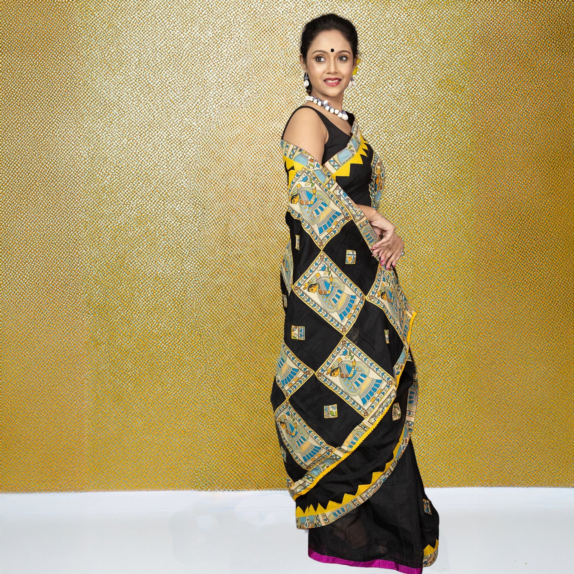 Side view of Heritage Bangaliyana Appliqué Saree in black cotton, adorned with vibrant folk motifs and yellow accents for festive styling.