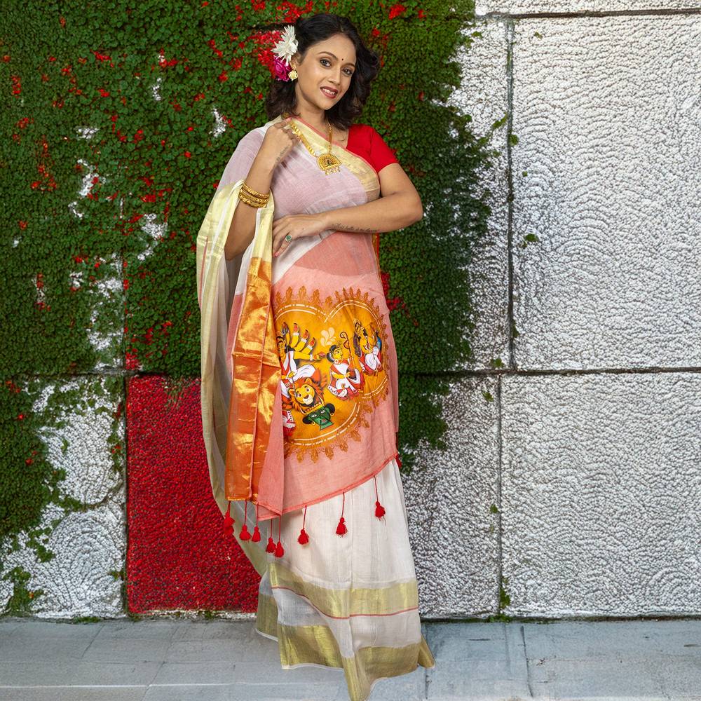 Heritage-inspired Chinmoyee Cotton Saree with Devi Durga artwork, red tassels, and golden accents, blending comfort with festive elegance.