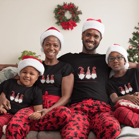 Family wearing matching black Christmas T-shirts with festive gnome design and 'Fa La La' text, paired with red holiday-themed pajamas.