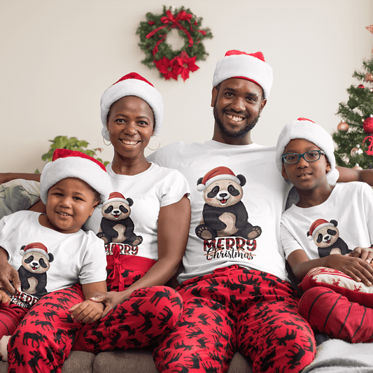 Family wearing matching Christmas panda t-shirts with Santa hats, sitting on a couch surrounded by holiday decorations.