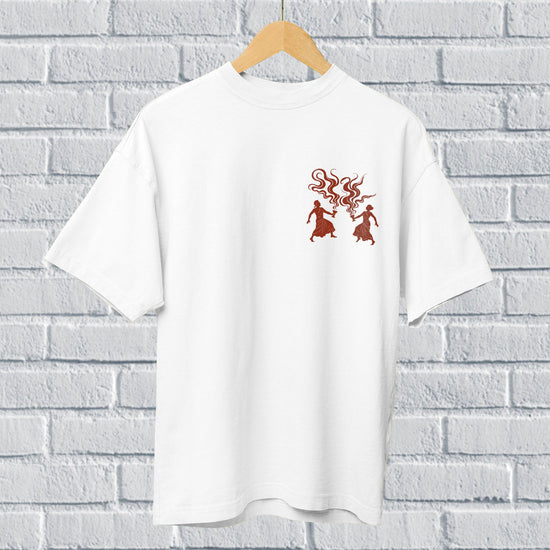 White oversized unisex Dhunuchi Dance Tee featuring minimal folk design of Durga Puja dancers in red. Ideal for celebrating Bengal's festive spirit.