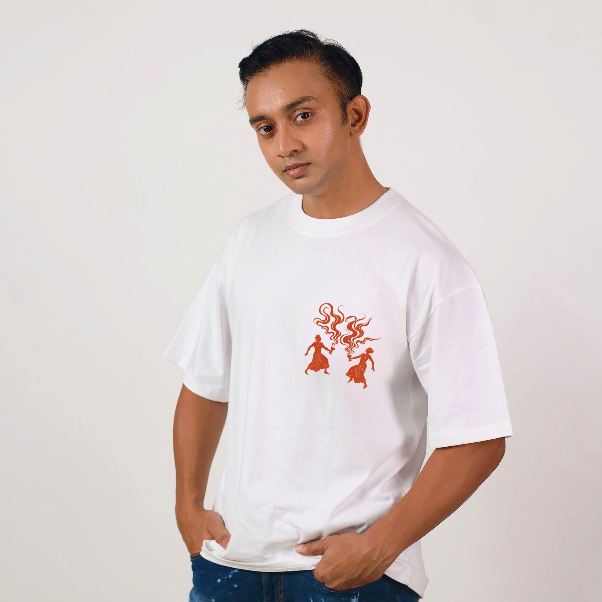Unisex oversized Dhunuchi Dance Tee for Durga Puja featuring minimal folk design in red on white cotton fabric. Ideal for festive cultural wear.