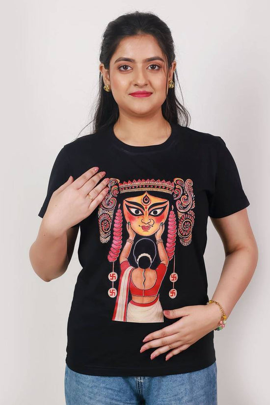 Woman wearing Durga Puja T-shirt with Boron tradition artwork, showcasing devotion and Bengali cultural heritage in festive apparel.