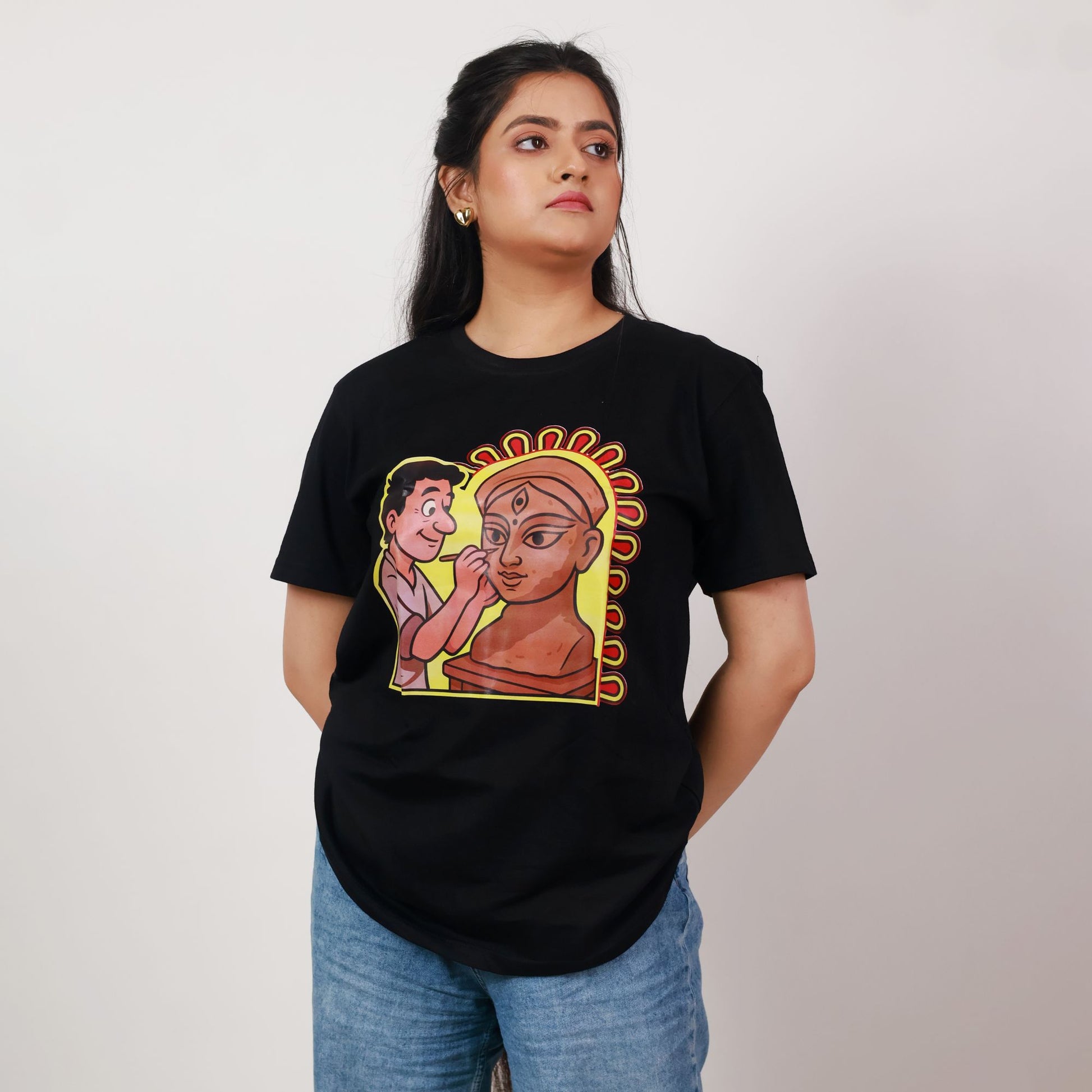 Durga Puja T-Shirt - Artistic Tribute | Premium Cotton, Unisex featuring cartoon-style idol maker sculpting Goddess Durga on black regular fit tee.
