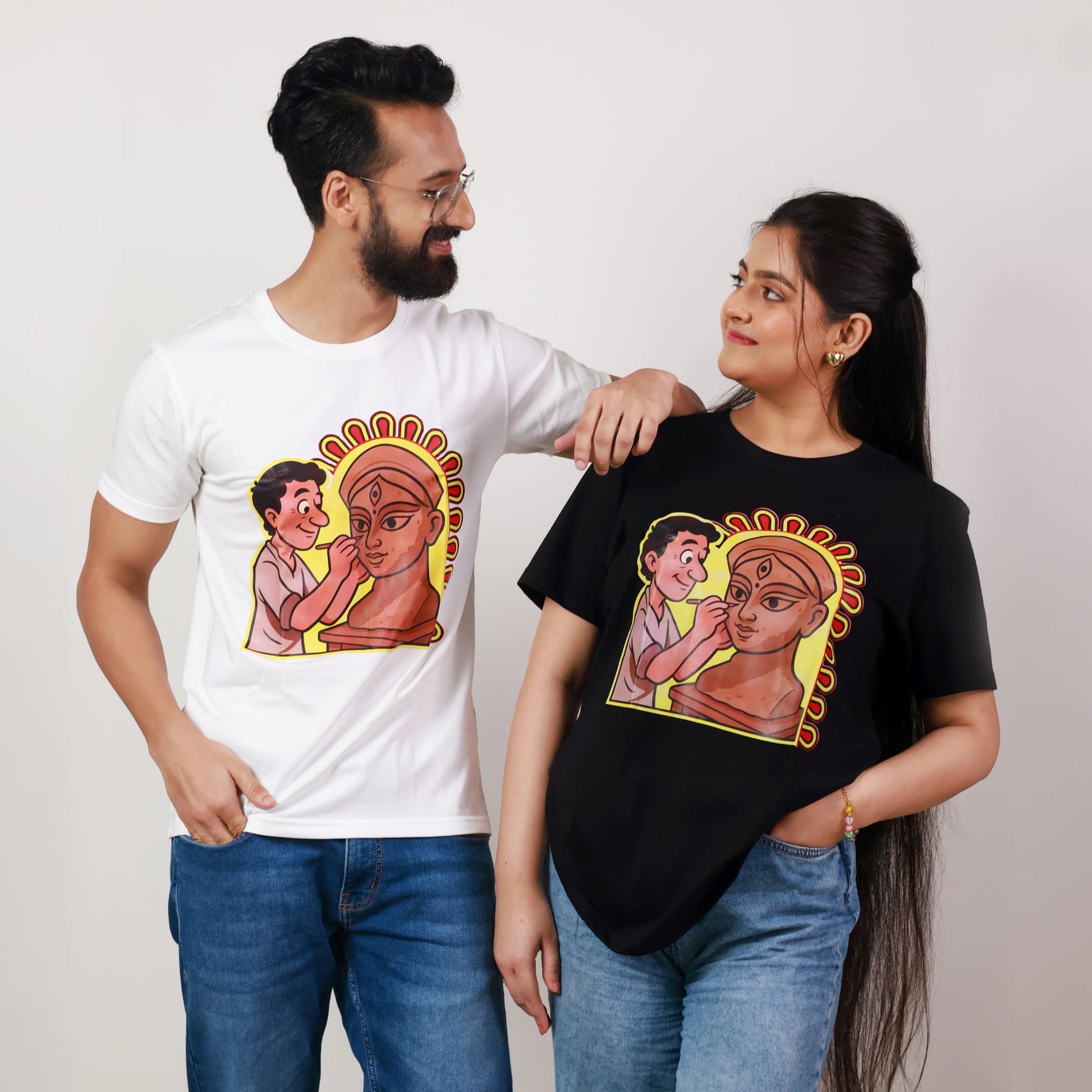 Durga Puja T-Shirt - Artistic Tribute | Premium Cotton, Unisex. Features cartoon-style idol maker with Durga on white cotton tee, perfect for festive wear.