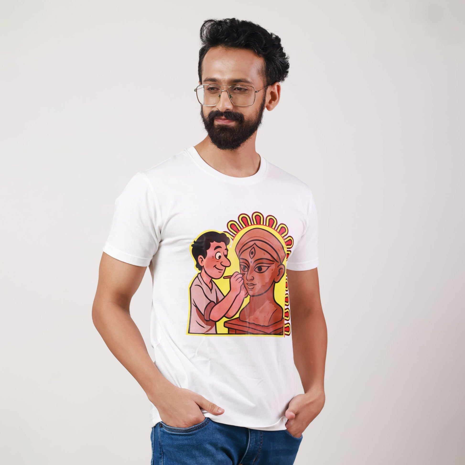 Durga Puja T-Shirt featuring cartoon-style idol maker sculpting Goddess Durga, printed on premium white cotton, unisex regular fit design.