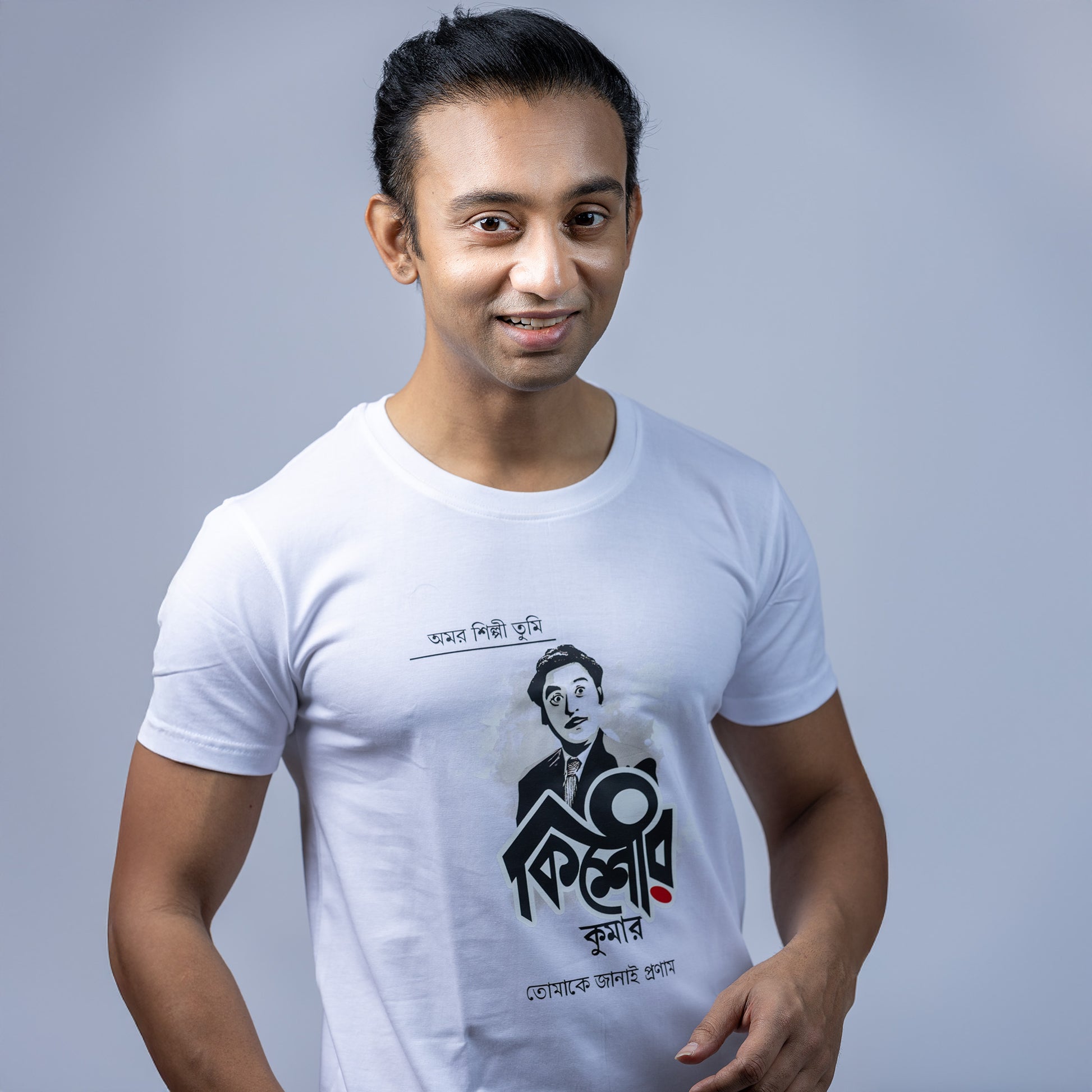 Man wearing a white Kishore Kumar unisex T-shirt with Bengali script, showcasing a stylish and comfortable fit.