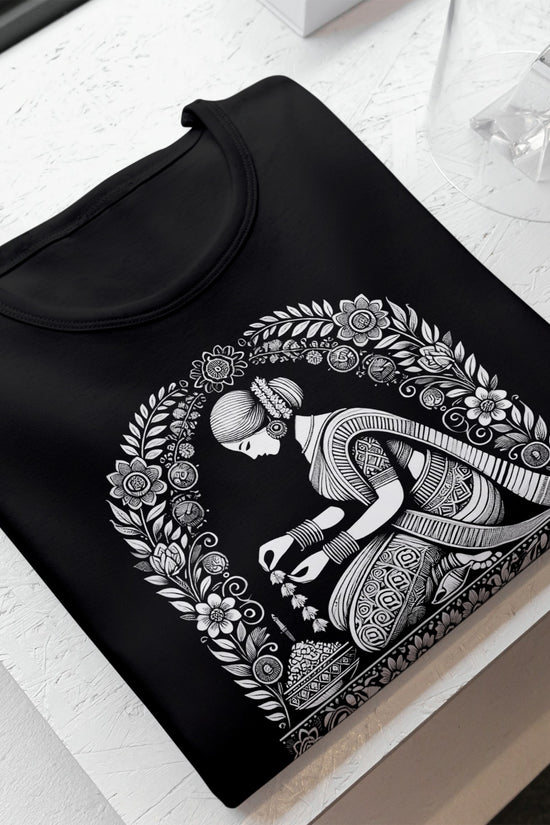 Malini - Bengali Alpona Graphic Tee in black, featuring intricate traditional floral motifs and a graceful female figure. Made from 100% cotton for unisex wear.