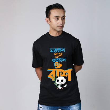 Man wearing black Jotokhhon Swas Totokhhon Bansh oversized Bengali T-shirt with funny panda and bamboo design.