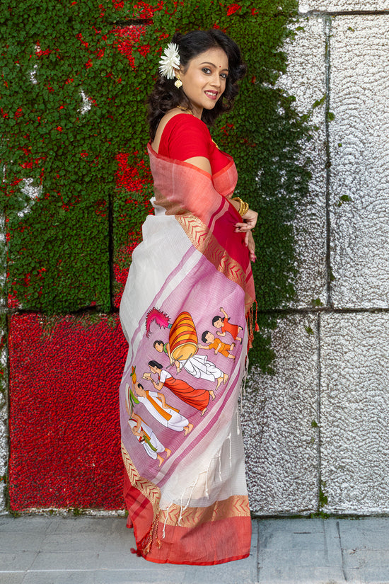 Heritage cotton saree with bold Durga Puja ritual artwork, blending comfort and tradition in a red-bordered ceremonial sari.