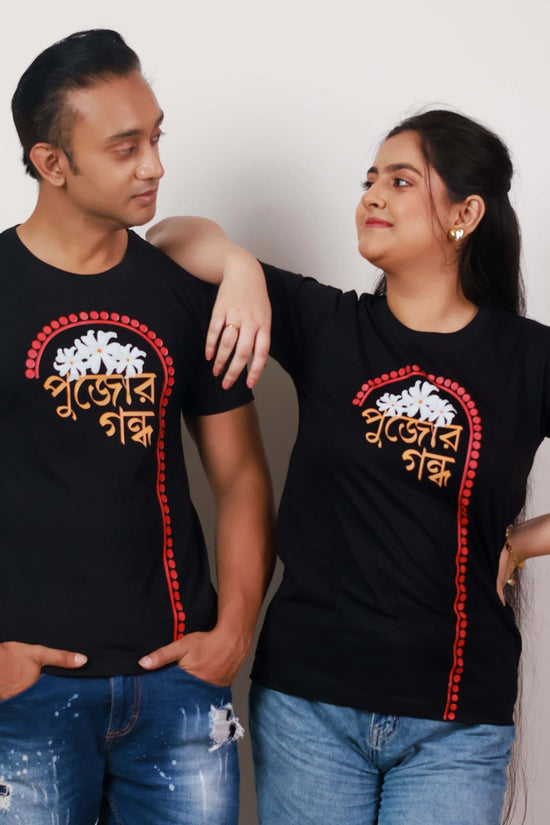 Durga Puja T-Shirt - Pujor Gondho in black with Bengali typography and sheuli flower design, unisex regular fit for festive wear.