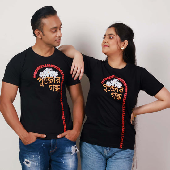 Durga Puja T-Shirt - Pujor Gondho in black with Bengali typography and sheuli flower design, unisex regular fit for festive wear.