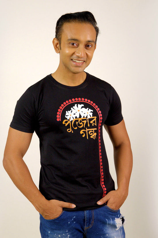 Durga Puja T-Shirt - Pujor Gondho in black with Bengali typography and sheuli flower design, unisex regular fit for festive wear.