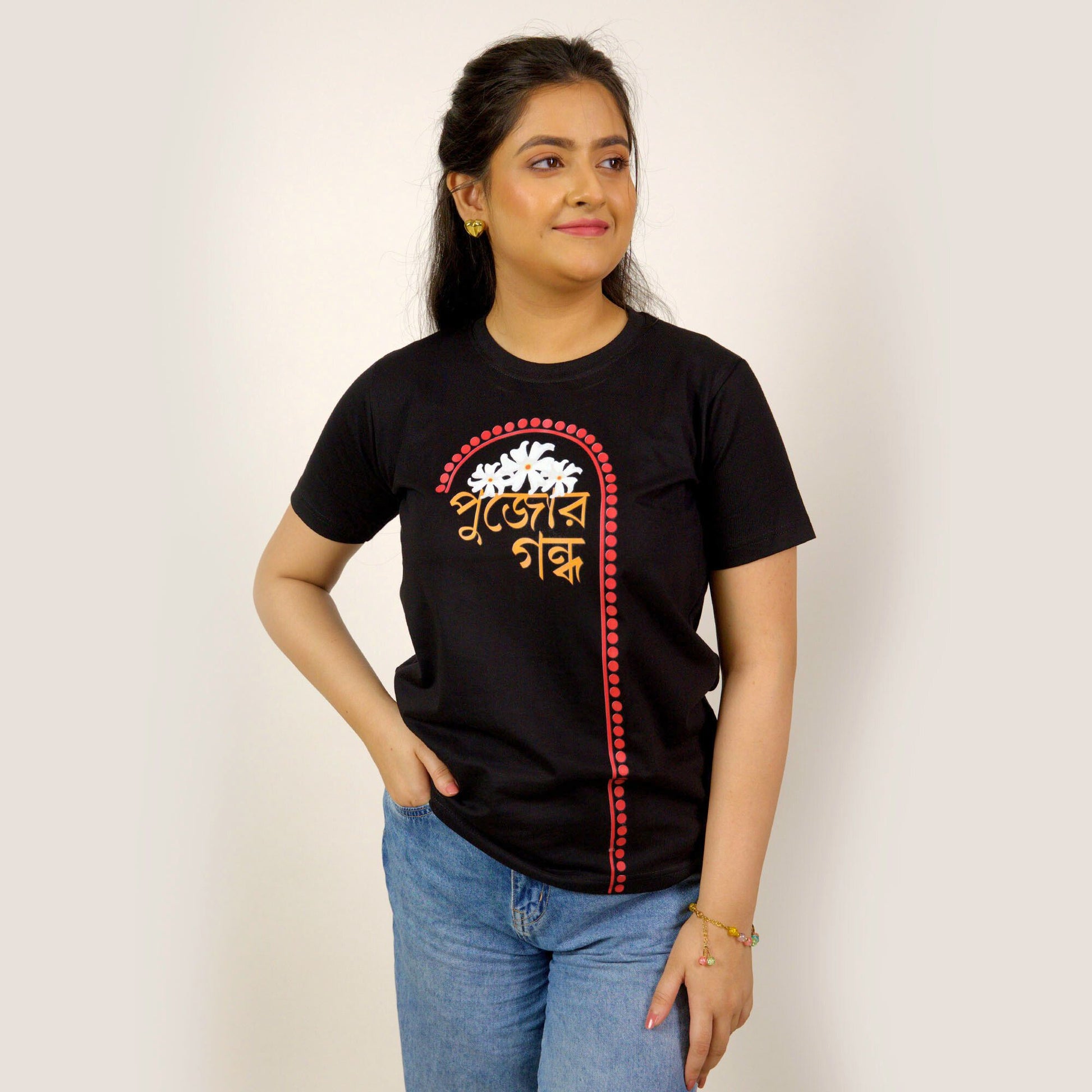 Durga Puja T-Shirt - Pujor Gondho in black with sheuli flower design and Bengali typography, unisex regular fit for festive wear.