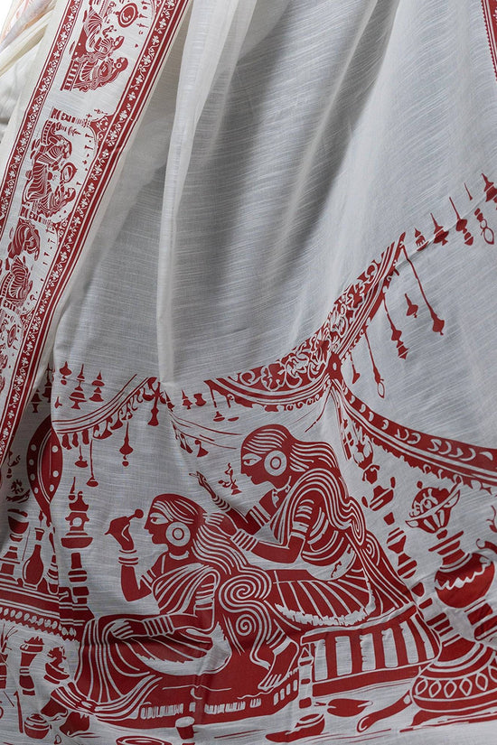 Close-up of Sringer khadi cotton saree showcasing intricate red Kalighat Patachitra artwork on white fabric.