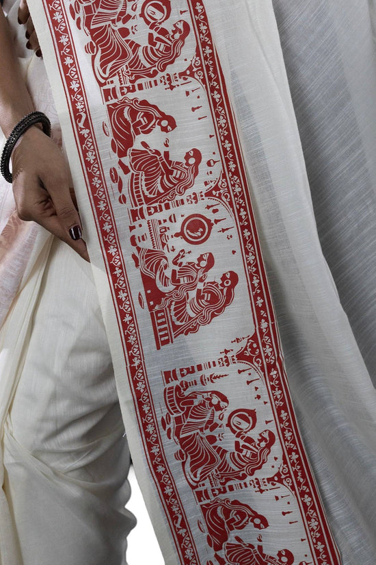 Detailed border of Sringer printed saree in khadi cotton featuring red Patachitra-style figures on white base.