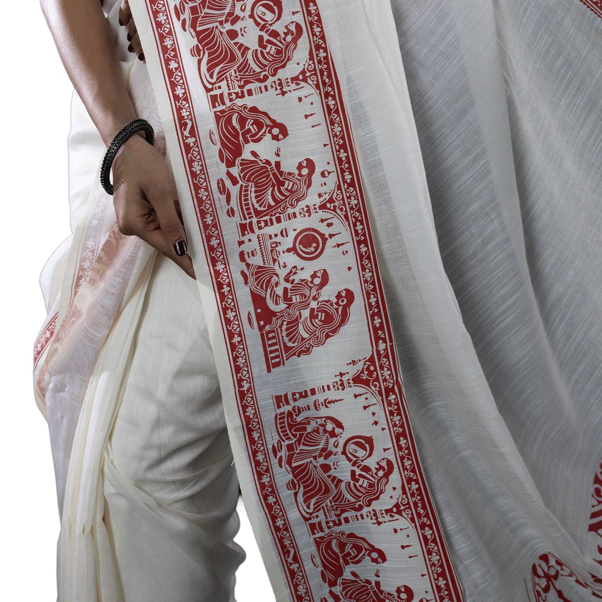 Detailed border of Sringer printed saree in khadi cotton featuring red Patachitra-style figures on white base.