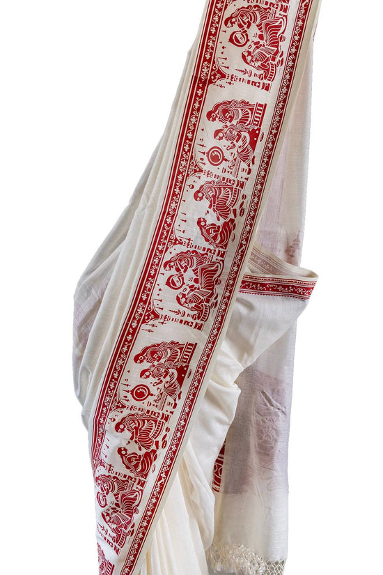 Sringer red on white printed khadi cotton saree featuring Kalighat Patachitra motifs along the border. Ideal for traditional and cultural wear.