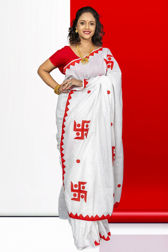 Traditional white and red Swastik Shubha cotton saree featuring sacred Swastika symbols, perfect for Durga Puja and ceremonial wear.