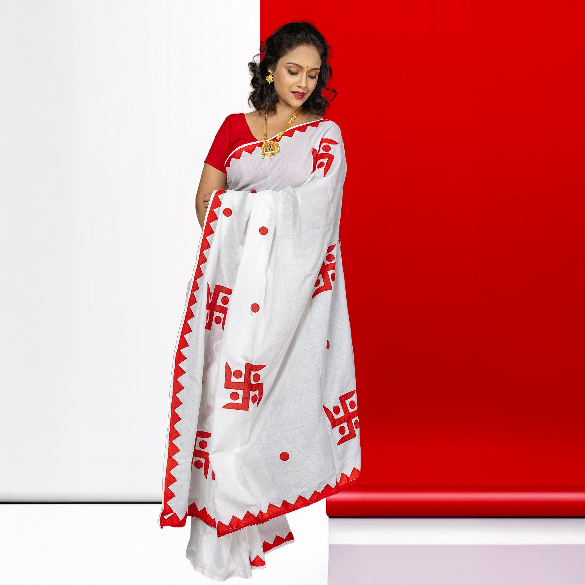 White cotton Swastik Shubha saree adorned with red Swastika appliqué and dotted accents, suitable for weddings and religious events.