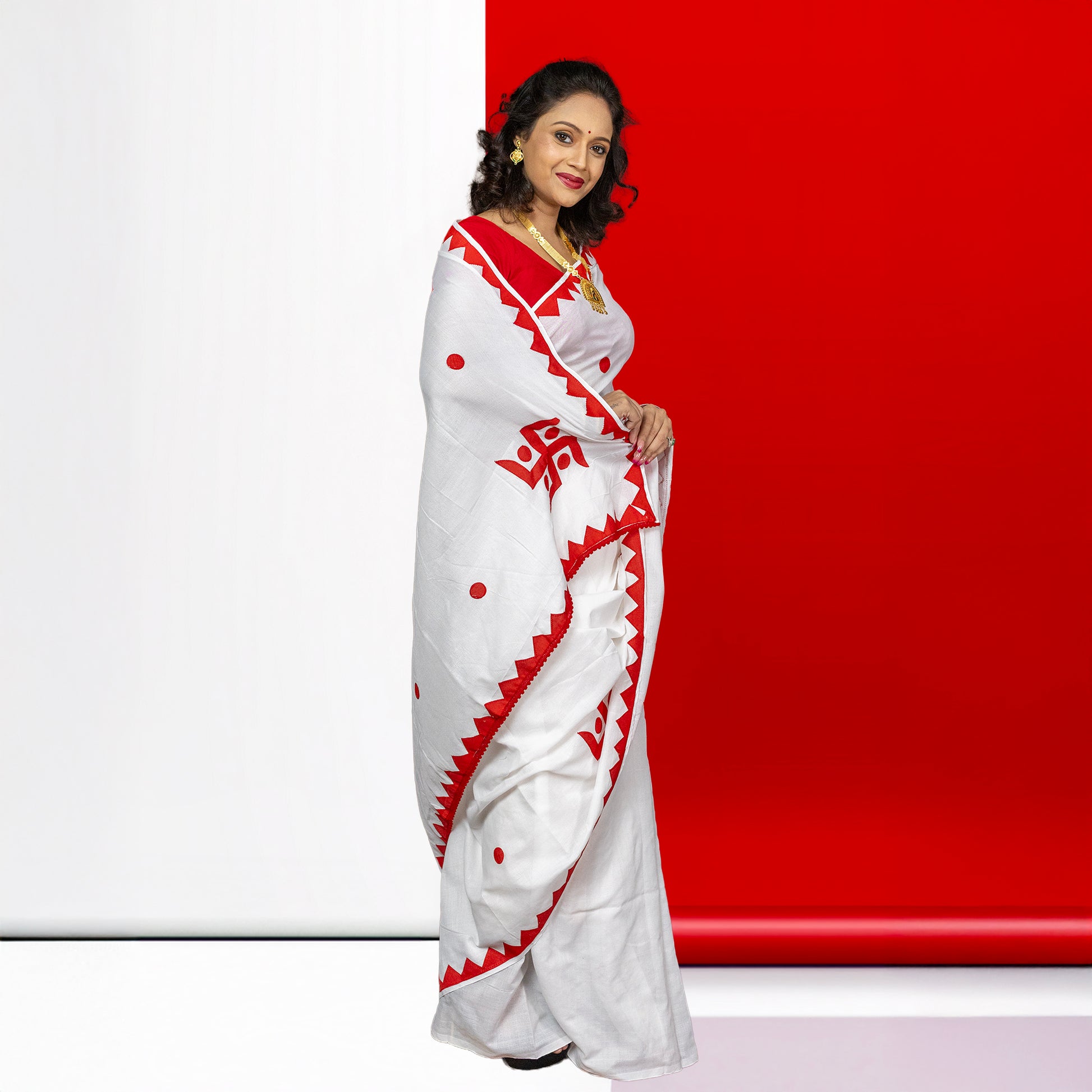 Swastik Shubha cotton saree in festive white and red, featuring sacred Swastika motifs and traditional design for ceremonial attire.