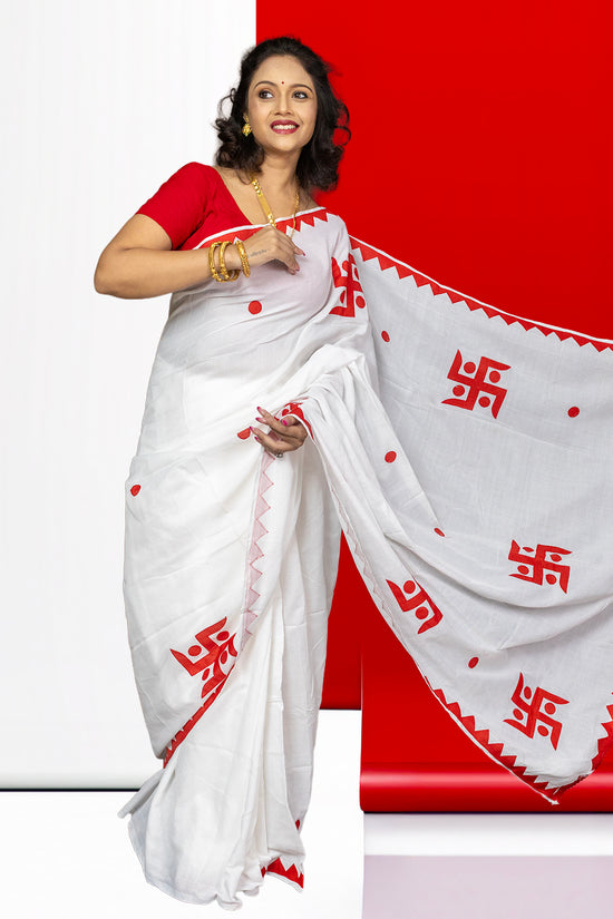 Swastik Shubha cotton saree in white with red appliqué Swastika motifs and zigzag border, ideal for festivals and weddings.