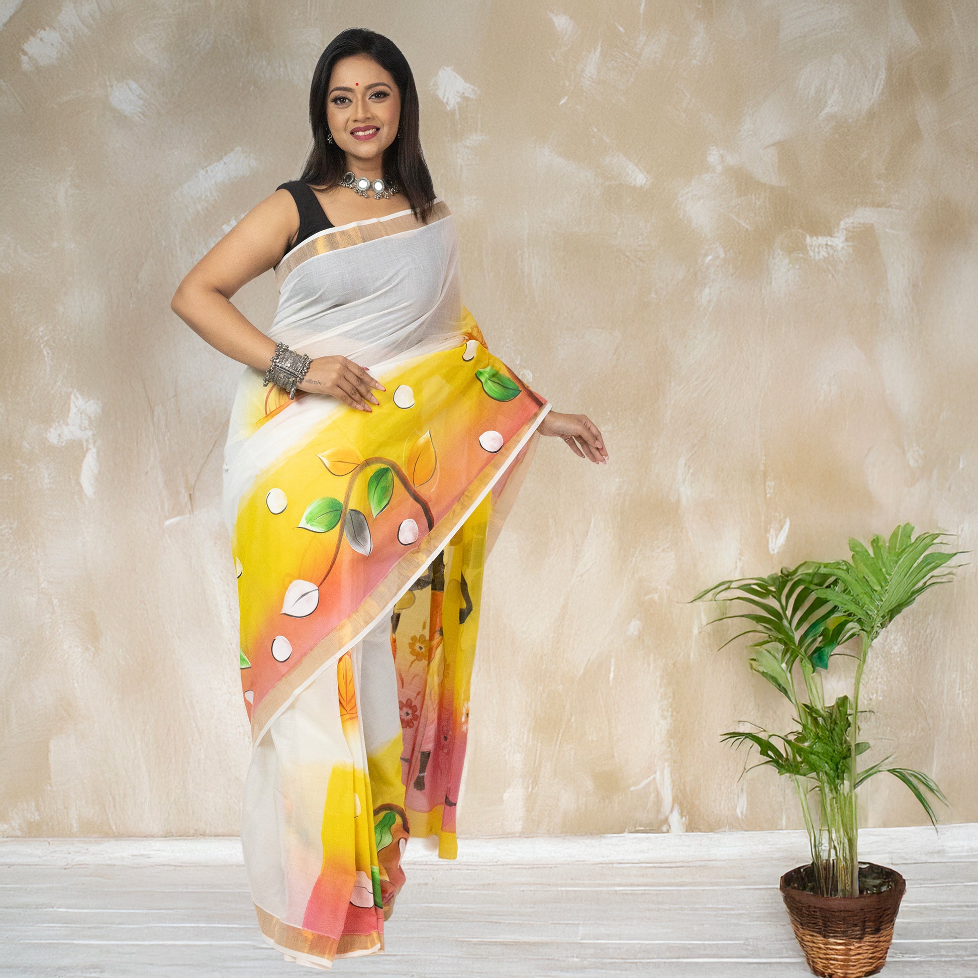 Elegant Tribal Tales hand-painted Kerala cotton saree with leaf and dot patterns, blending folk art with contemporary ethnic fashion.