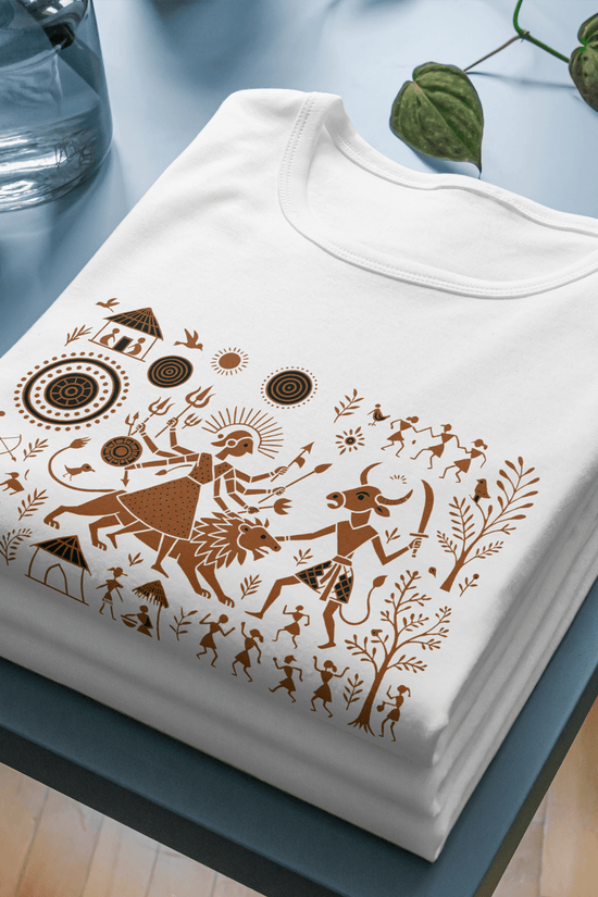 Durga T-Shirt - Warli Art Mahishasura design in brown on folded white cotton unisex tee, showcasing spiritual and cultural heritage.