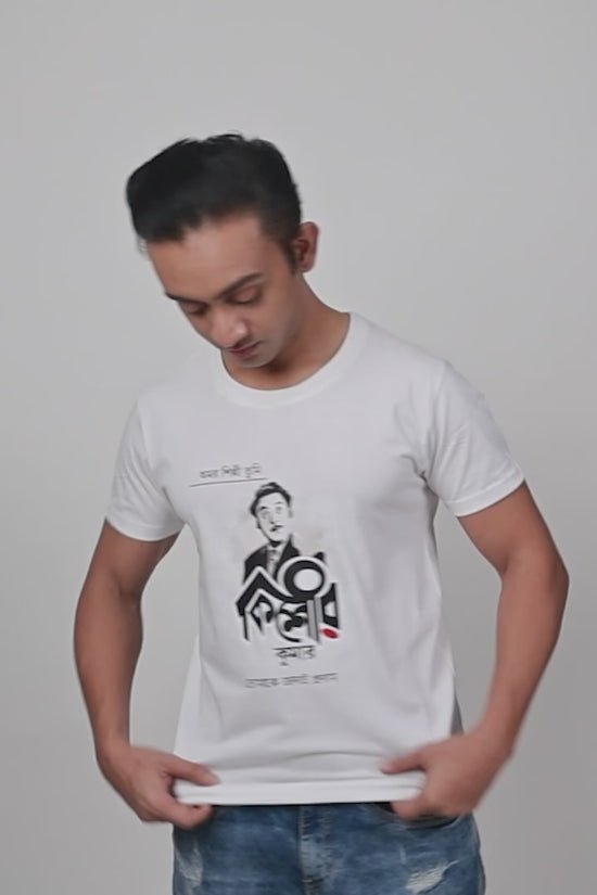 Model showcasing a white unisex T-shirt with a Kishore Kumar graphic design in Bengali script, paired with casual denim jeans.